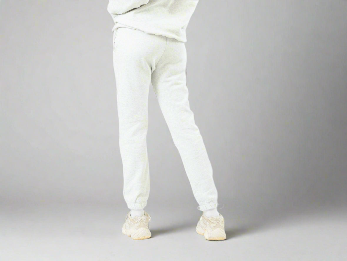 Person wearing a white hoodie and pants on a white background